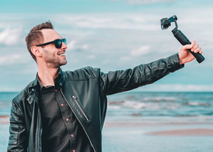 Mężczyzna chwali się dobrym selfie stickiem ze stabilizatorem obrazu