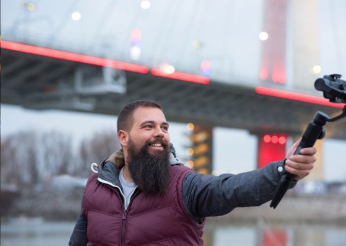 Mężczyzna robi sobie selfie przy pomocy selfie sticka z LED